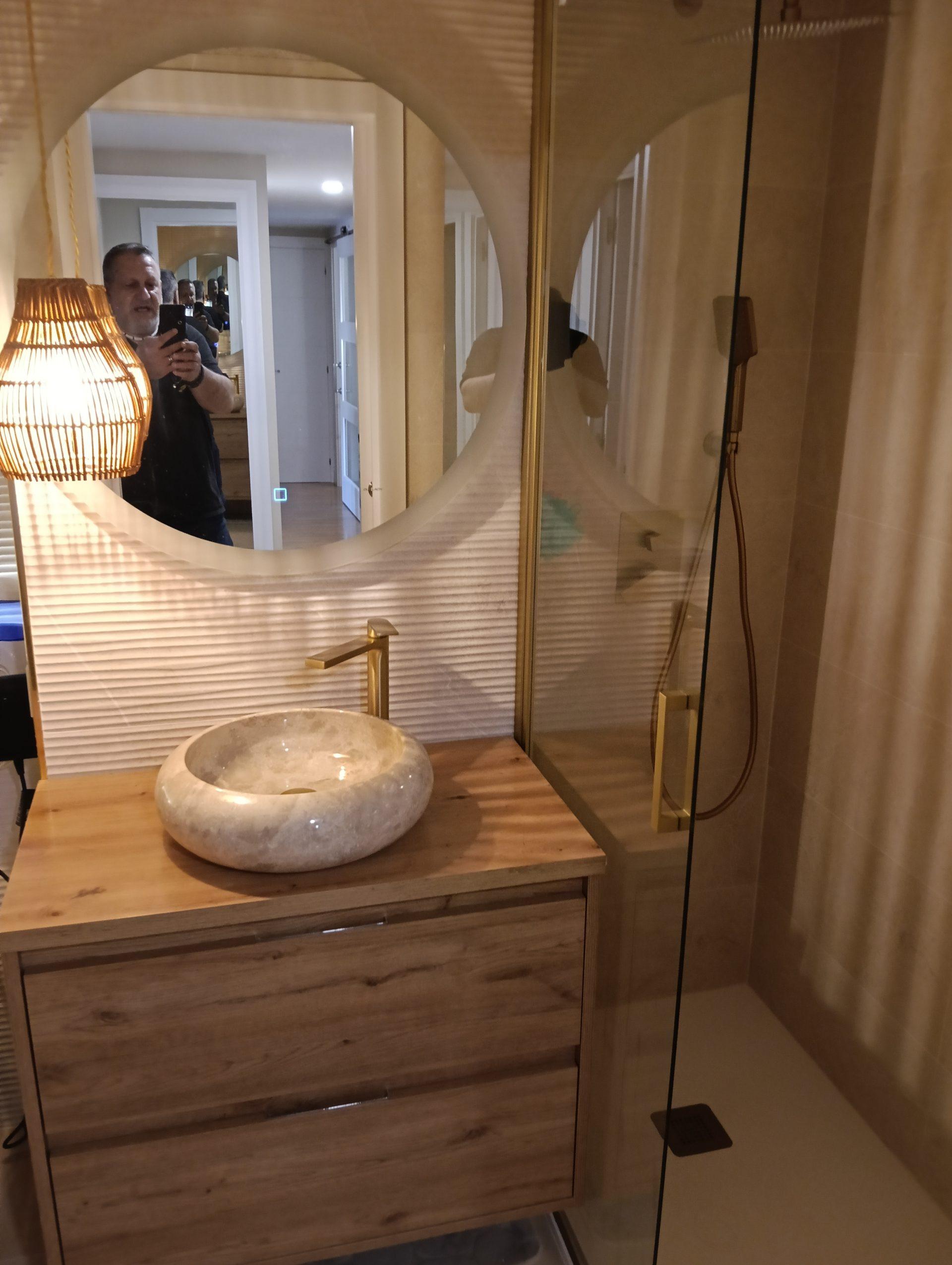 Hombre sacando foto a baño moderno de madera